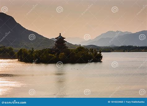 Chinese Pagoda On An Island In The Middle Of Water And Mountains Stock