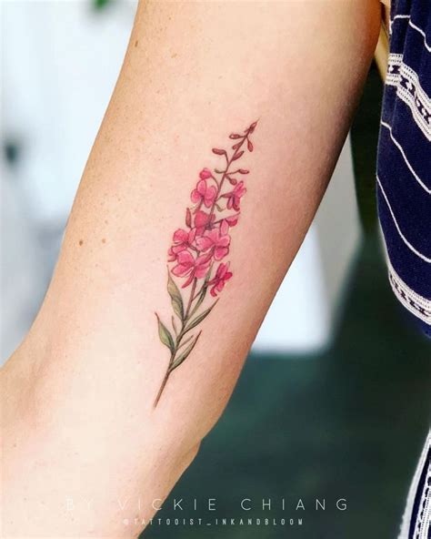 a small pink flower tattoo on the arm