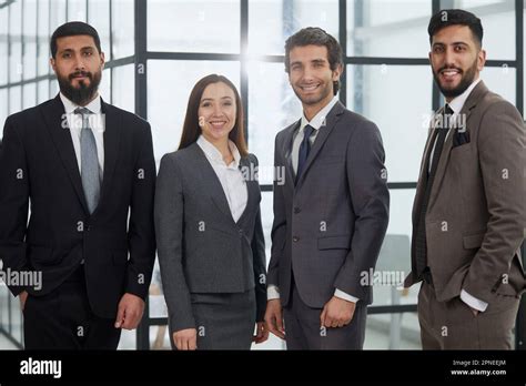 Businessmen With Brunette In Group Posing In Office Lobby Stock Photo Alamy