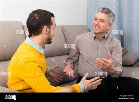 Mature Father And Son Are Friendly Conversation Sitting At Home On Sofa Stock Photo Alamy