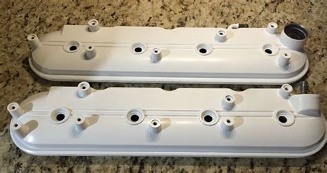 Two White Valve Covers Sitting On Top Of A Counter