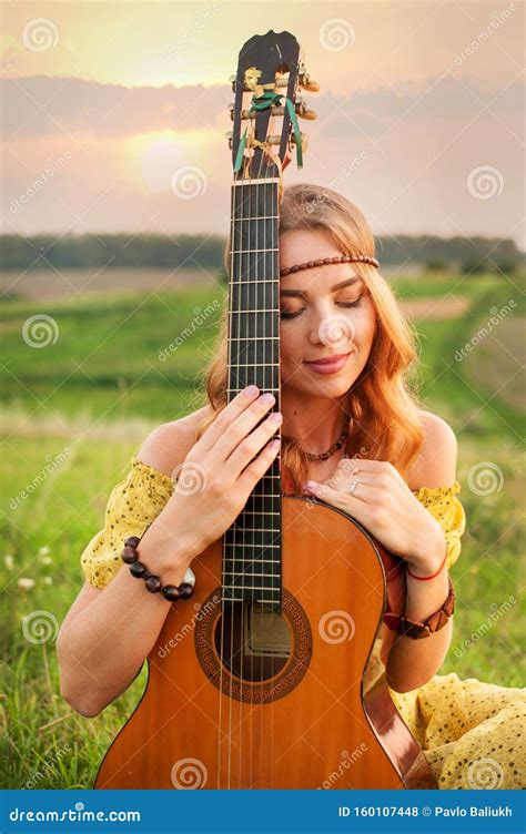 Girl In Yellow Dress Bohemian Style Holding A Guitar On The Field