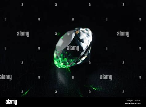 Illuminated Diamond With Green Light On Black Background Stock Photo