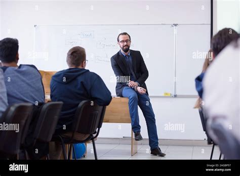 Group of students study with professor in modern school classroom. Male ...