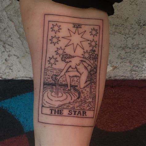 a tarot card tattoo on the leg of a person's leg with stars above it