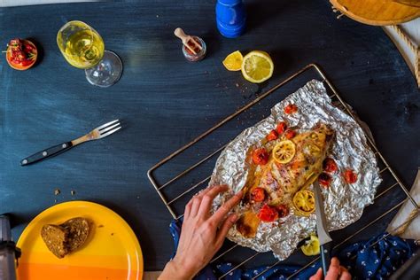 Premium Photo Baked Fish With Vegetables On The Table With Different