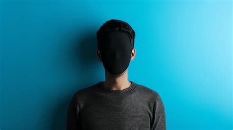 A Man With A Black Mask On His Head Is Standing In Front Of A Blue