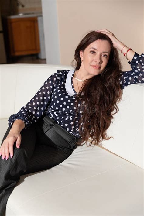 Beautiful Brunette Woman Sitting On A White Sofa At Home Stock Image Image Of Interior Cute