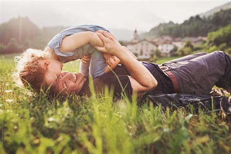 Happy Father And Daughter Snuggling And Laughing On A Summer Field By