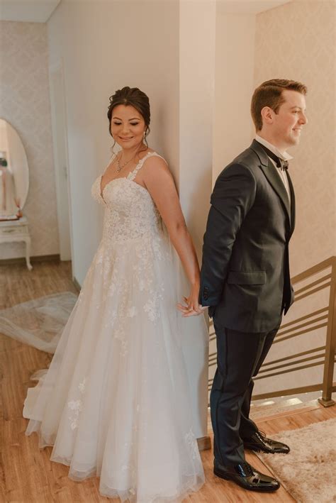 A Bride And Groom Standing Next To Each Other In Front Of The Stairs At