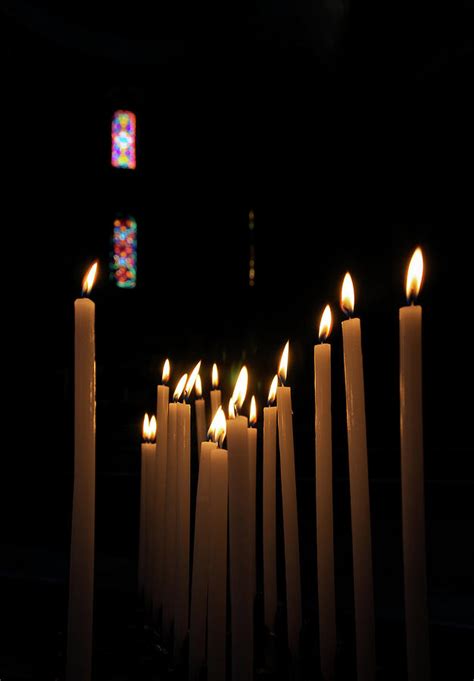 Votive Candles Burning In A Church In by Gregory Adams