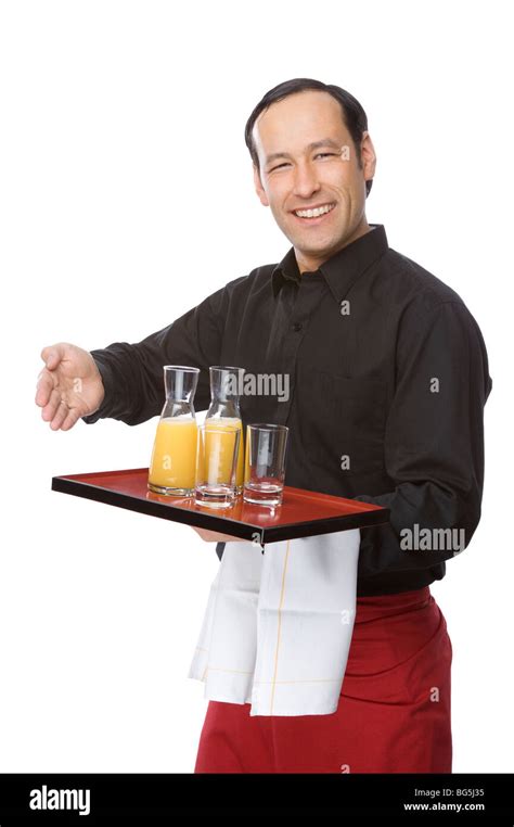 Male Waiter Smiling And Pouring Orange Juice Stock Photo Alamy