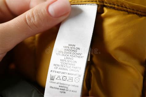 Woman Reading Clothing Label With Care Symbols And Material Content On