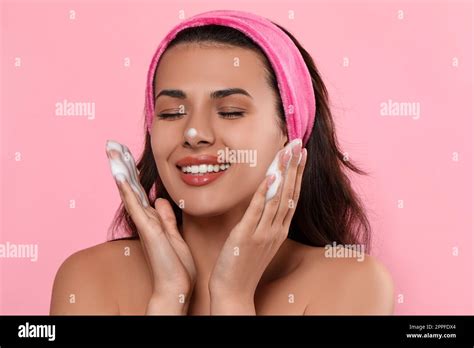 Beautiful Woman Applying Facial Cleansing Foam On Pink Background Stock