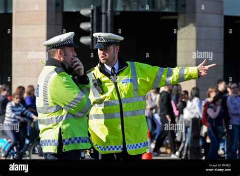 Two Uniform Metropolitan Traffic Police Officers Talking About A