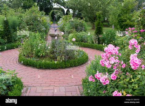 fall phlox, garden phlox (Phlox paniculata), garden with sundial ...