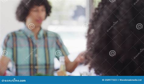 Happy Group Of Diverse Friends Sitting At Table And Eating Dinner