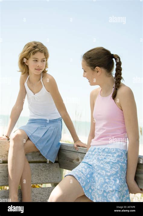 Las Niñas Preadolescentes Sentado En La Baranda Hablando En Beach Fotografía De Stock Alamy