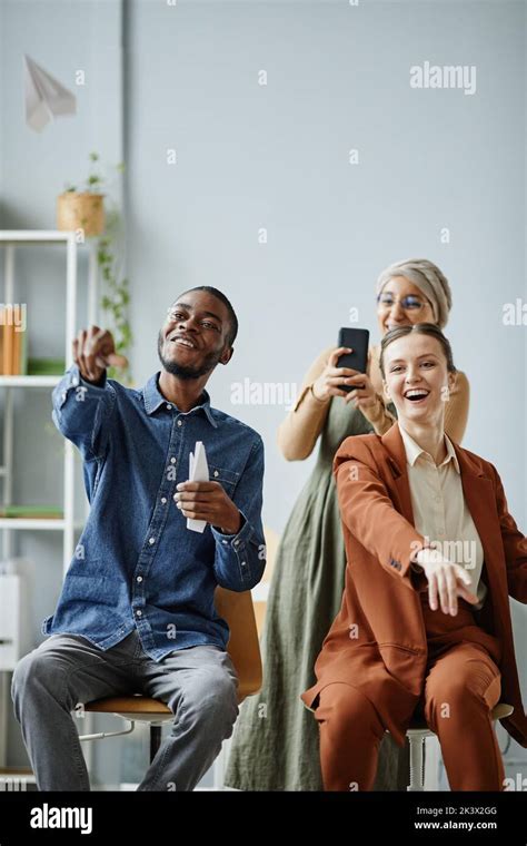 Vertical Portrait Of Young Diverse Team Having Fun In Office And