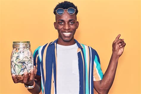 Joven Afroamericano Sosteniendo Un Frasco Con Ahorros Sonriendo Feliz