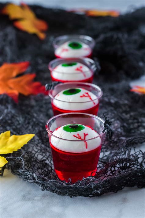 Three Cups Filled With Jello Sitting On Top Of A Black Cloth Covered