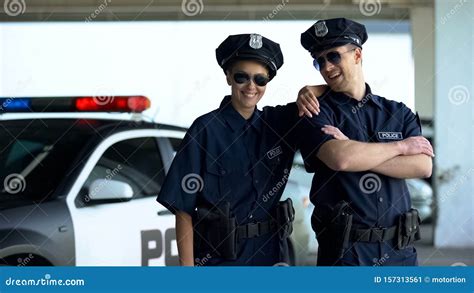 Friendly Police Officers In Uniform And Glasses Smiling To Camera Law