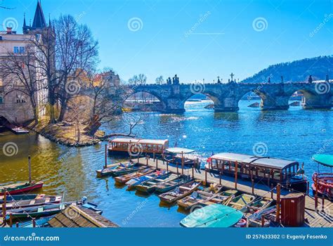 The Small Pier With Old Wooden Boats On Vltava River With A View On