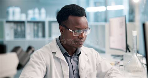 Black Man Scientist And Chemicals In Beaker At Lab For Research