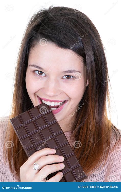 Portrait Of A Satisfied Pretty Girl Biting Chocolate Bar Portrait Stock