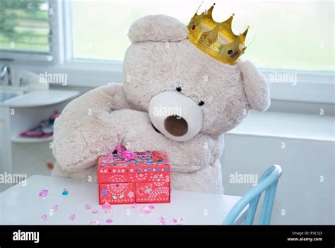 A Big Teddy Bear With A Royal Crown Examines A Pile Of Glittering