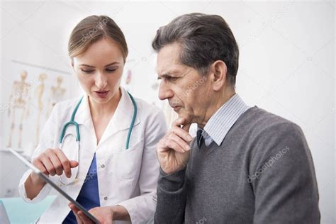 Médico mostrando los resultados del examen en la tableta digital 2023