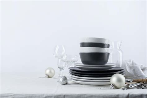 Premium Photo | Set of black and white tableware with plates cutlery and glasses with holiday ...