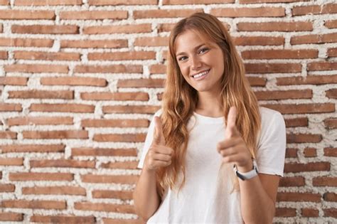 Mujer Cauc Sica Joven De Pie Sobre La Pared De Ladrillos Se Alando Con