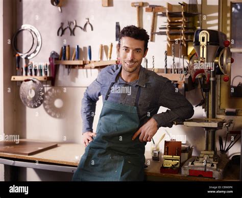 Portrait of adult italian man at work as craftsman in shop with tools in background Stock Photo ...