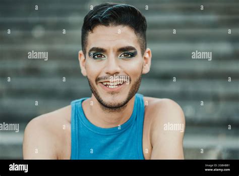 Jeune homme gay souriant sur la caméra en plein air dans la ville Focus sur le visage Photo
