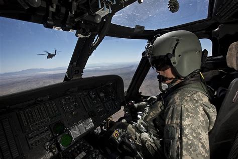 Pilot operating the cockpit of a UH-60 Black Hawk helicopter. Poster ...