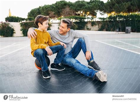 Lächelnder Vater umarmt Sohn am Strand ein lizenzfreies Stock Foto