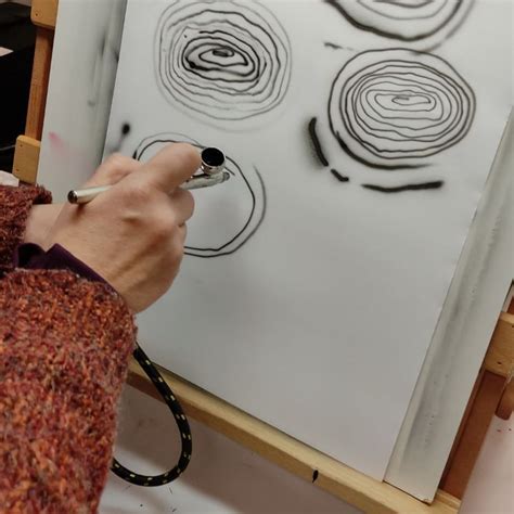 A Person Drawing Circles On A Piece Of Paper