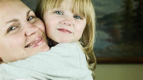 Mother Makes Up Lips To The Daughter And Then They Embrace Stock