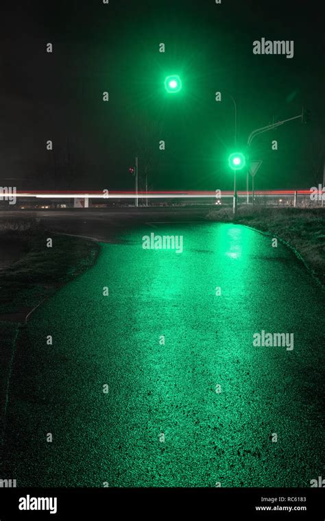 Traffic light showing green light in wet night Stock Photo - Alamy