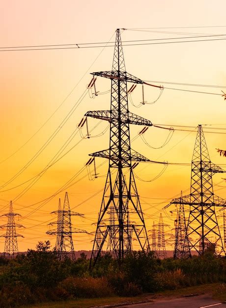 Líneas de transmisión contra el cielo rojo de la tarde torres de