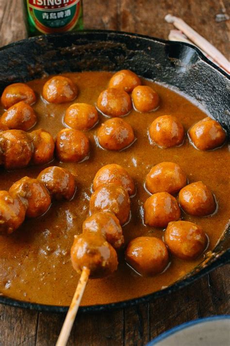 meatballs and gravy are being served in a skillet with chopsticks