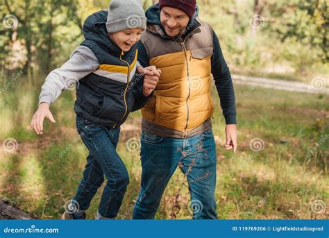 Cheerful Father And Son Holding Hands While Walking Together Stock