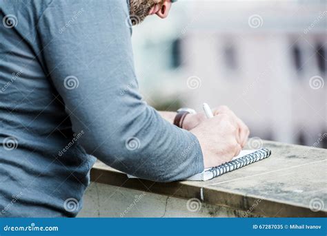 Man Writing Something On A Notebook Close Up Side View Stock Image