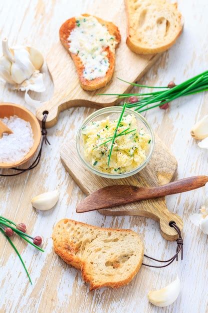 Mantequilla de ajo casera con hierbas y cebolletas y baguette recién