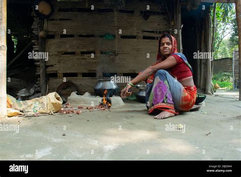 Rural Woman Cooking Food In The Kitchen Using Firewood Stove Stock