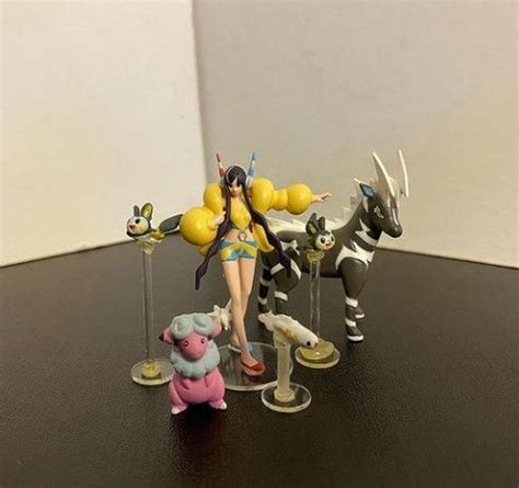 Some Figurines Are Sitting On A Table With One Girl Holding Balloons