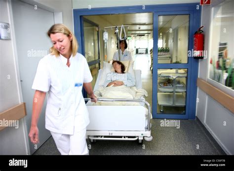 Hospital Nurses Moving A Female Patient In Her Bed From Her Hospital