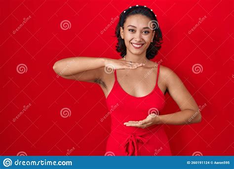 Young Hispanic Woman Standing Over Red Background Gesturing With Hands