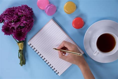 Premium Photo Woman Writing On Her Notebook On A Blue Background